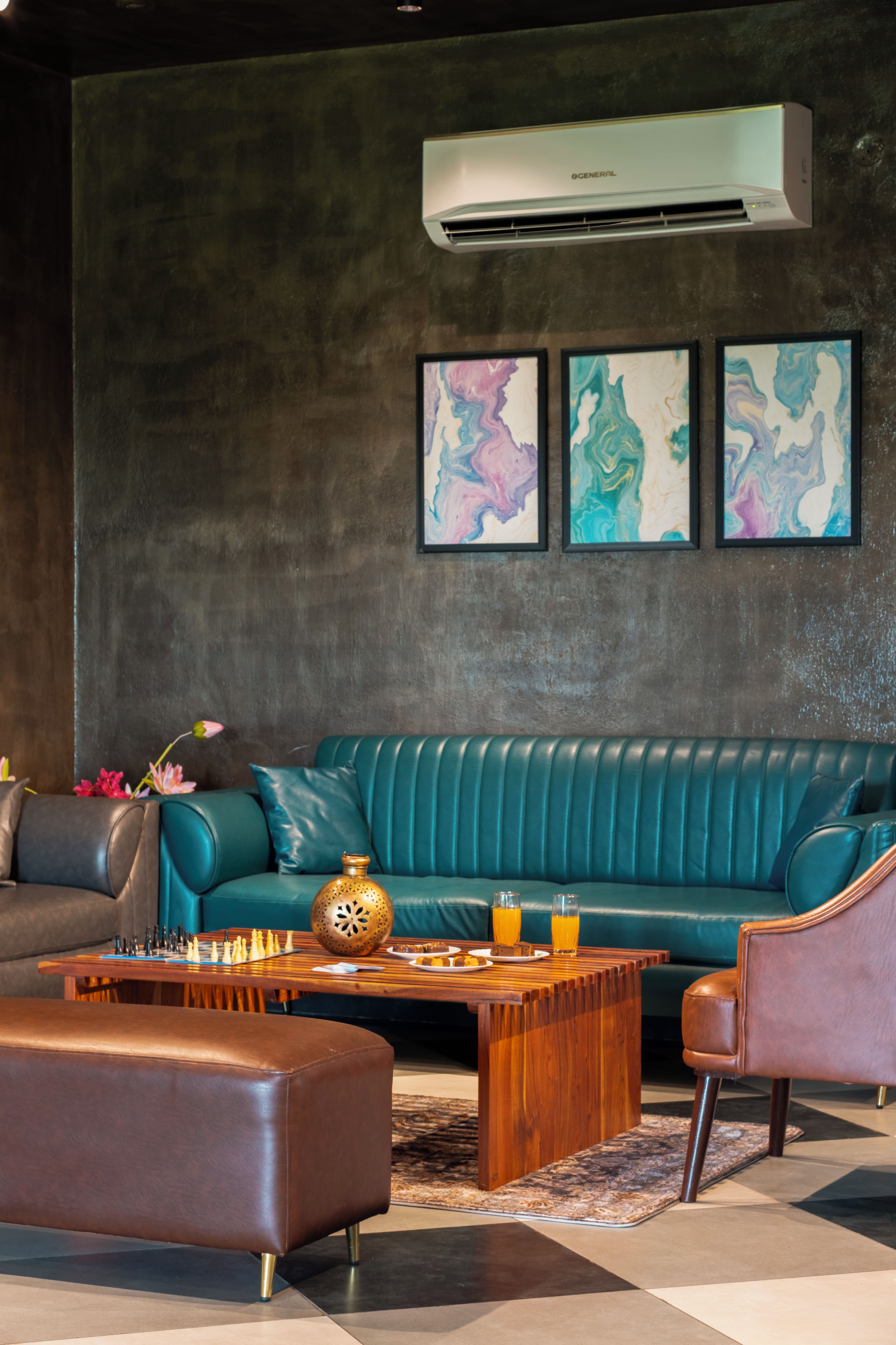 Una sala de estar moderna con un sofá color turquesa, una mesa de centro de madera y un reposapiés de cuero.