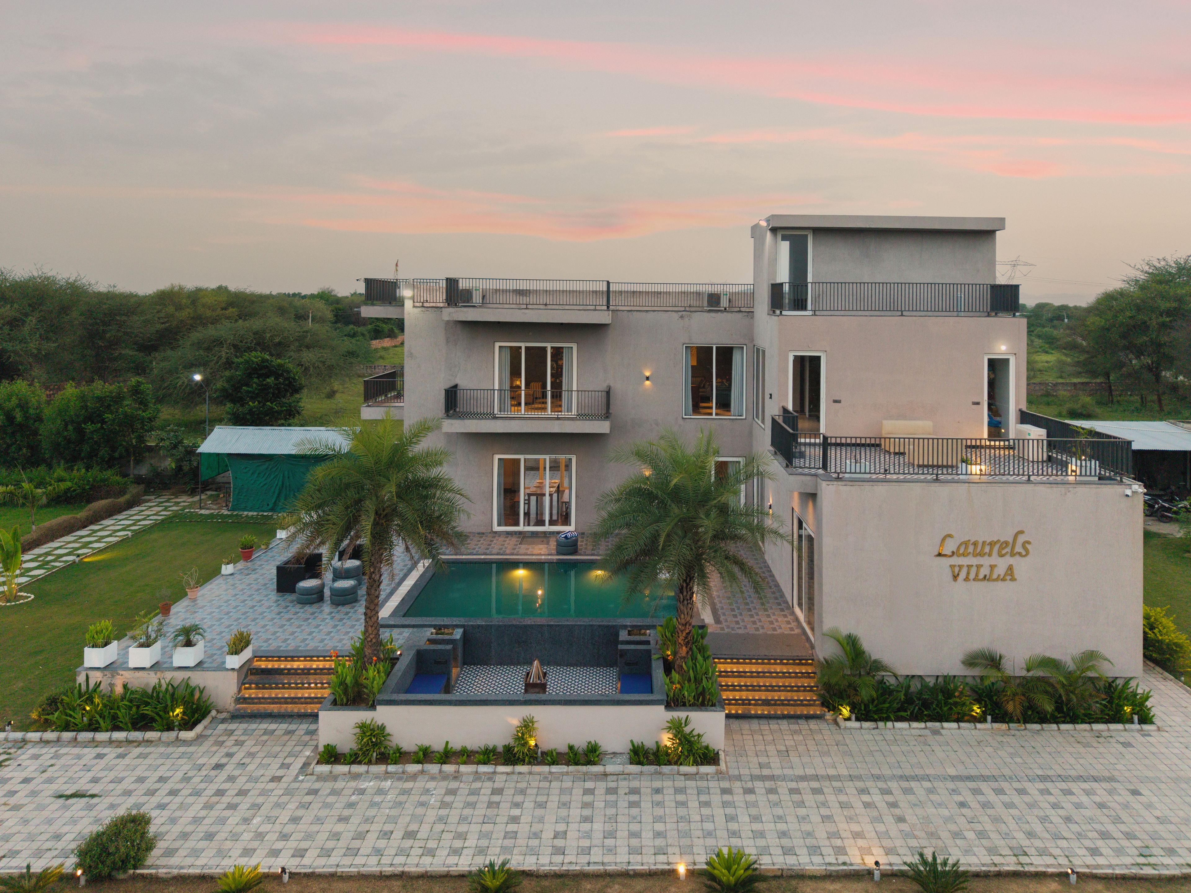 Una villa moderna con piscina, mobiliario exterior y un jardín bien cuidado.
