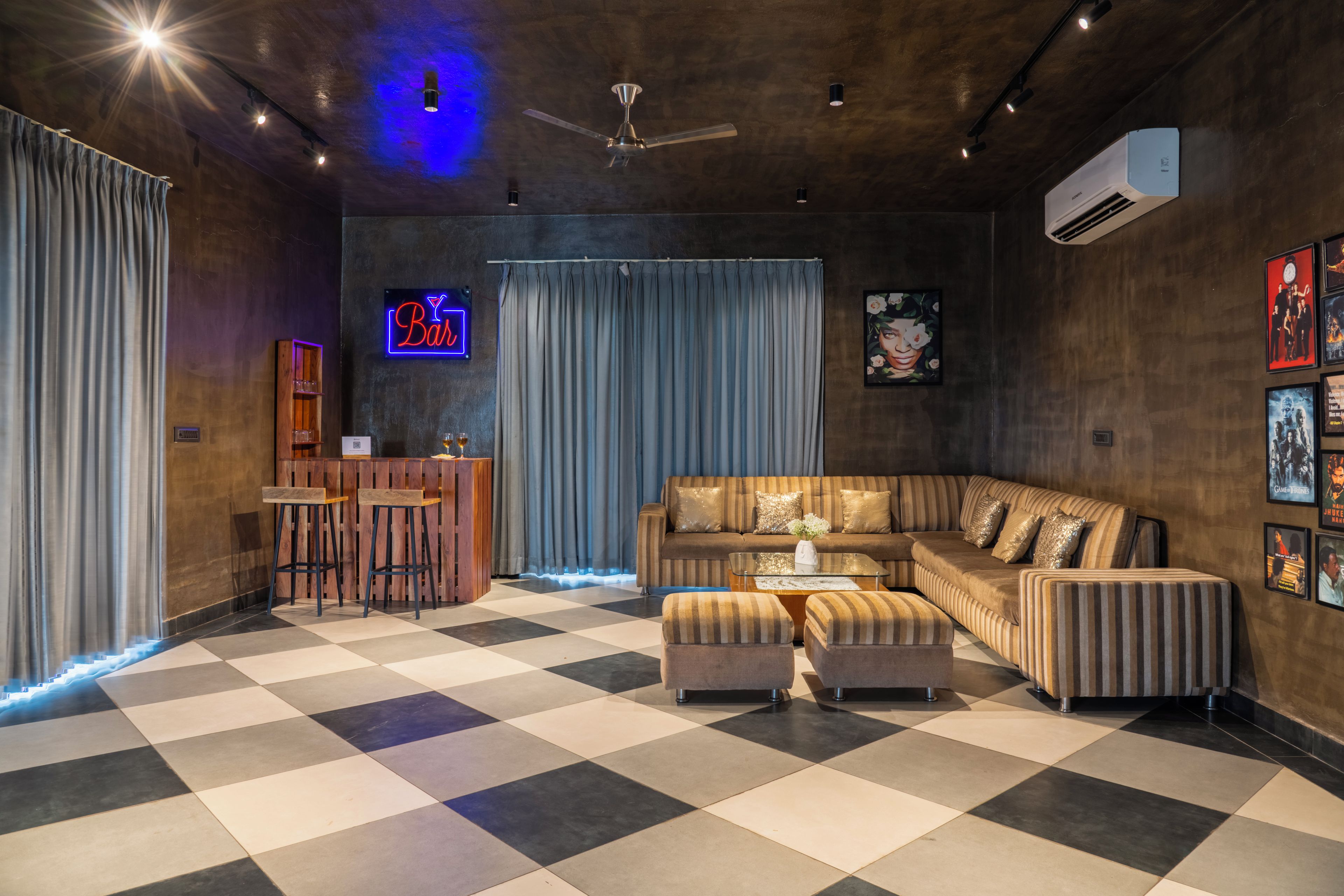 Una sala moderna con piso a cuadros, una zona de bar y un letrero de neón.
