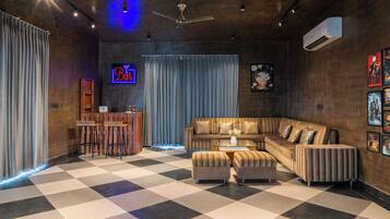 Una sala moderna con piso a cuadros, una zona de bar y un letrero de neón.