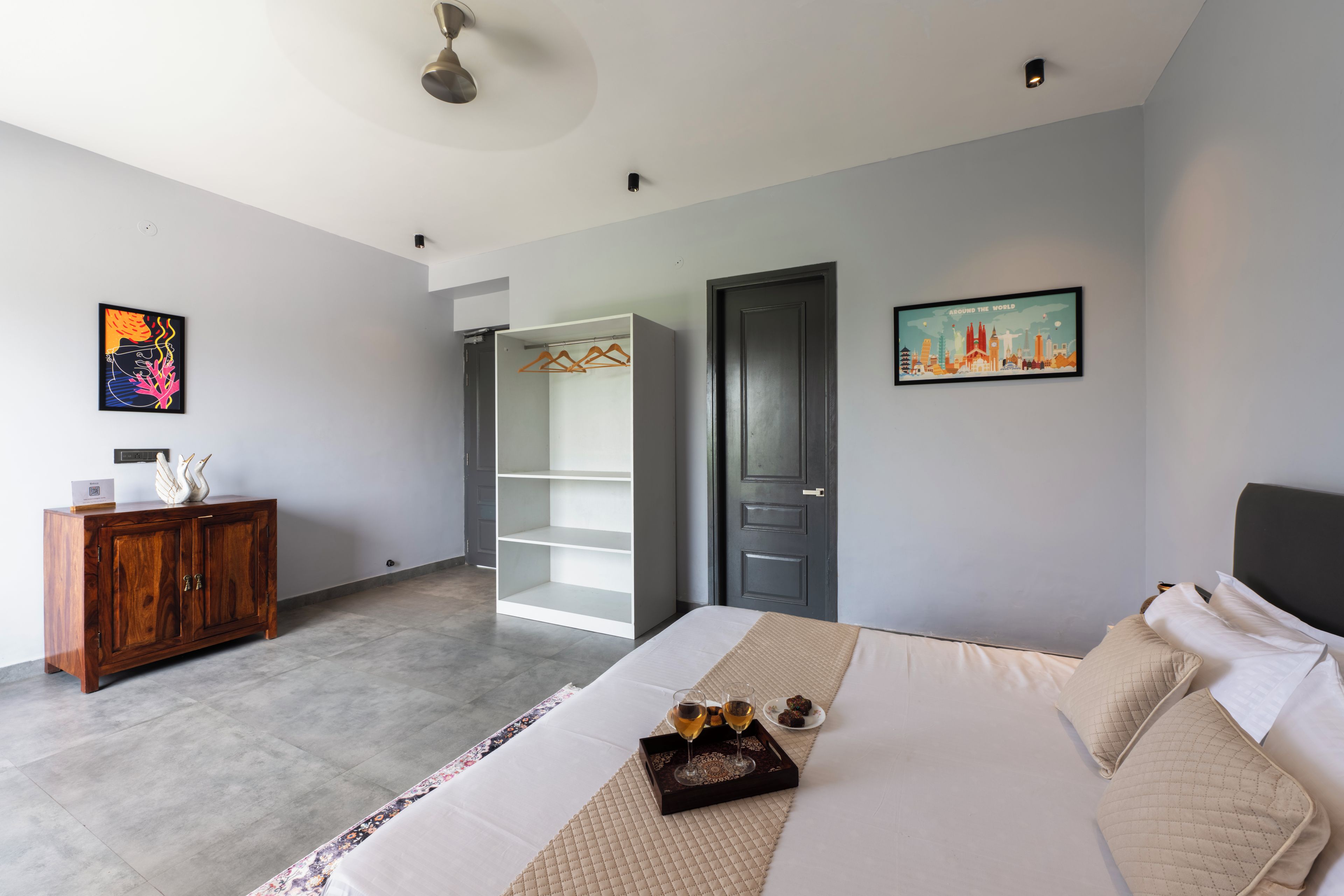 Un dormitorio moderno con cama, armario, un cuadro y vistas al exterior.