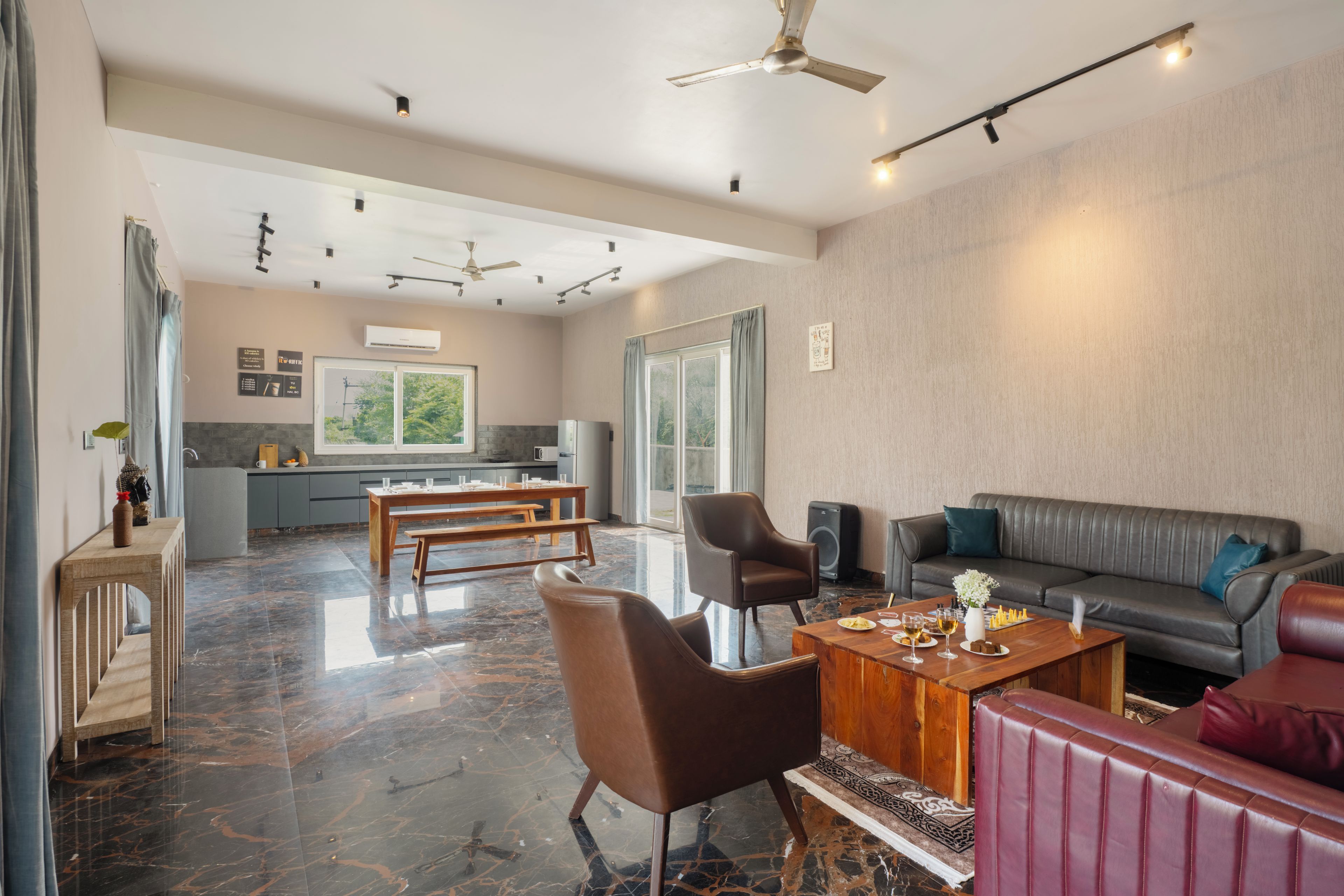 A modern living room with a sofa, a coffee table, and a dining area with a bench and table.