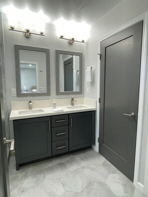 A bathroom with two sinks, a dark door, and a mirror above the sink. - 3 Bedroom, sleeps 8, house centrally located in San Diego (San Diego)