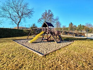 Ein Spielplatz mit Rutsche und Klettergerüsten.