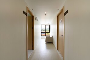 A hallway with doors labeled 'R503' and 'P504,' leading to a room with a window. - Kamala Fantasia 2-bdr Apartment by TVC (Tambon Kamala)