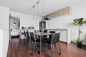 A modern kitchen with a dining area, wooden flooring, and a potted plant. - Flower (Furano)