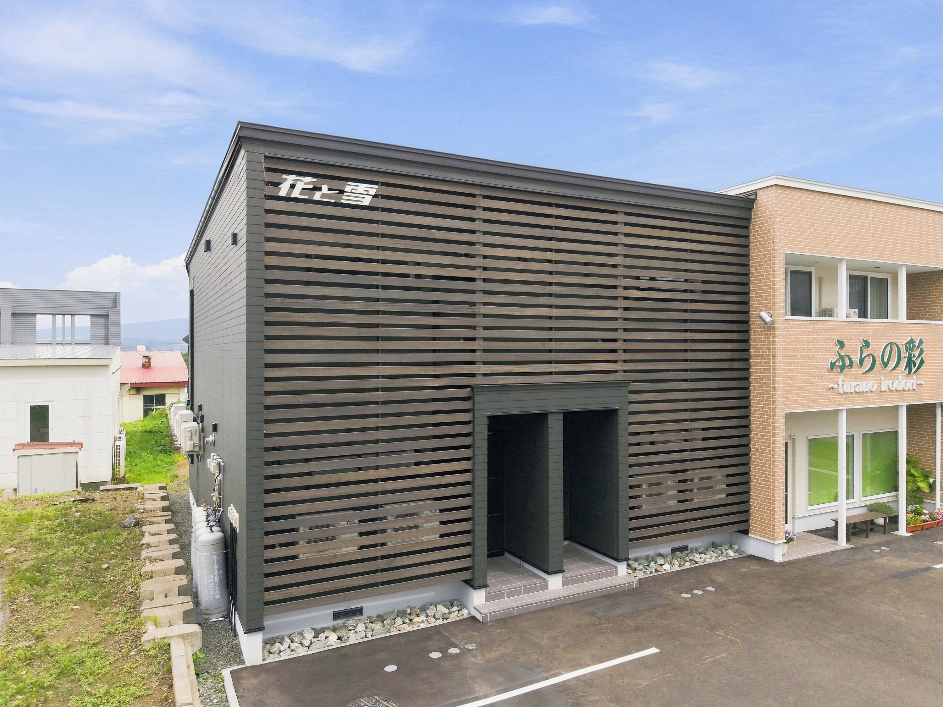 A modern building with a slatted facade and a clear entrance.