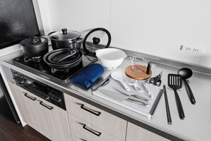 A kitchen with a stove, pots, a cutting board, a bowl, a measuring cup, and various utensils. - Flower (Furano)