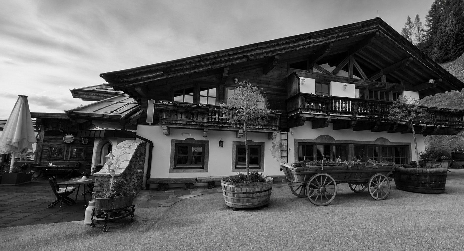 A traditional chalet with a balcony, wooden exterior, and a carriage in front.