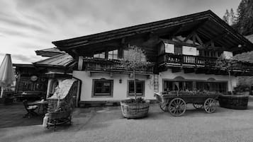 A traditional chalet with a balcony, wooden exterior, and a carriage in front.