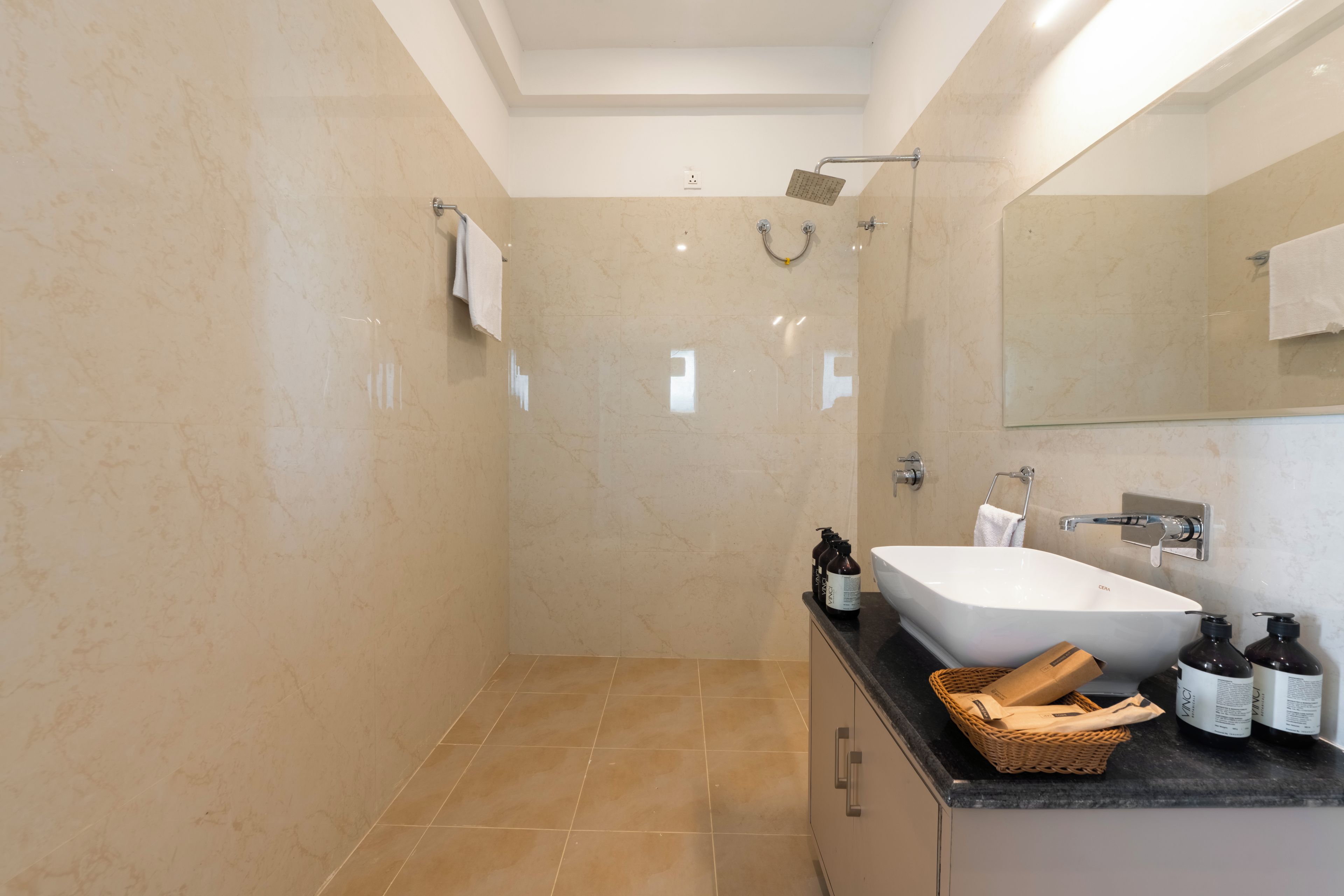 A modern bathroom with a bathtub, a shower, and a vanity with toiletries.