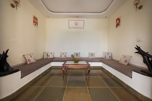 A room with a brown sofa set, a wooden coffee table, and a tiled floor. - ELIVAAS Signature Vijaypura Bagh 6BHK (Vijaipura)
