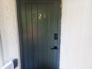 A dark-colored door with a number '24' and a keypad lock. - Apartment F24 by Interhome (Negril)