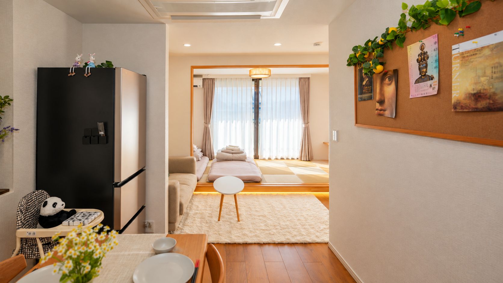 Un intérieur moderne comprenant un espace cuisine, un coin repas et un salon avec un canapé et des coussins.