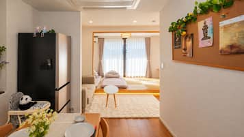 Un intérieur moderne comprenant un espace cuisine, un coin repas et un salon avec un canapé et des coussins.