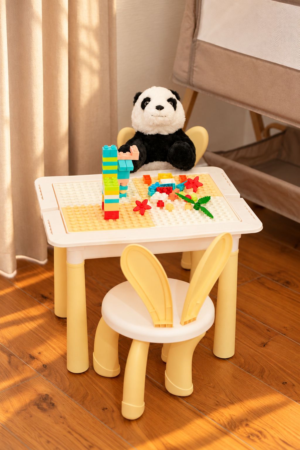 Une petite table avec un ours en peluche et des cubes de construction.