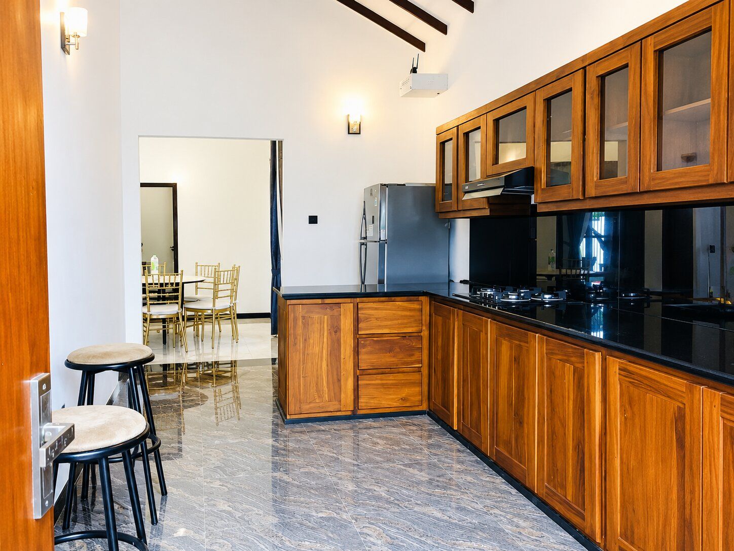 A modern kitchen with wooden cabinets, a black countertop, and stainless steel appliances.