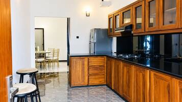 A modern kitchen with wooden cabinets, a black countertop, and stainless steel appliances.