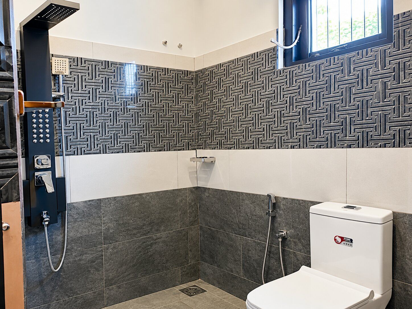 Un baño moderno con ducha, inodoro y panel de control.