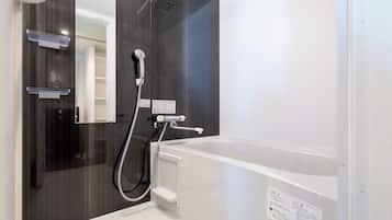 A modern bathroom with a bathtub, a shower, and a mirror.