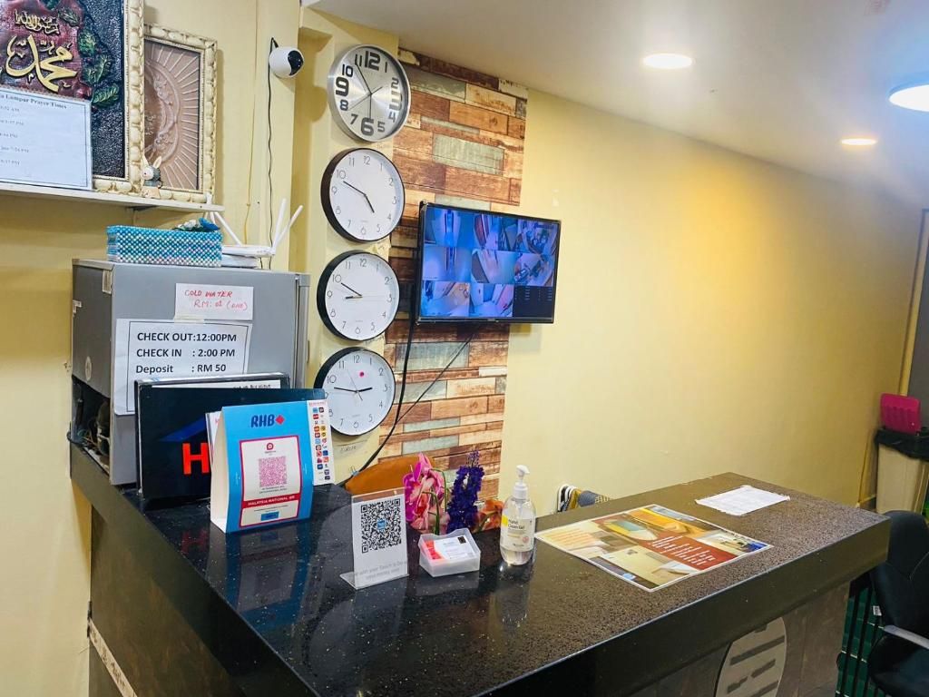 Una recepción de hotel con relojes, un televisor y un mostrador de registro.