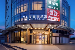 Ein moderner Hotel Eingangsbereich mit Glasfassade, beleuchteter Beschilderung und einladendem Ambiente.
