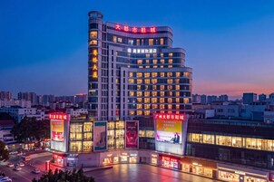 Ein modernes Hotel mit mehreren Stockwerken und einem markanten Eingang.
