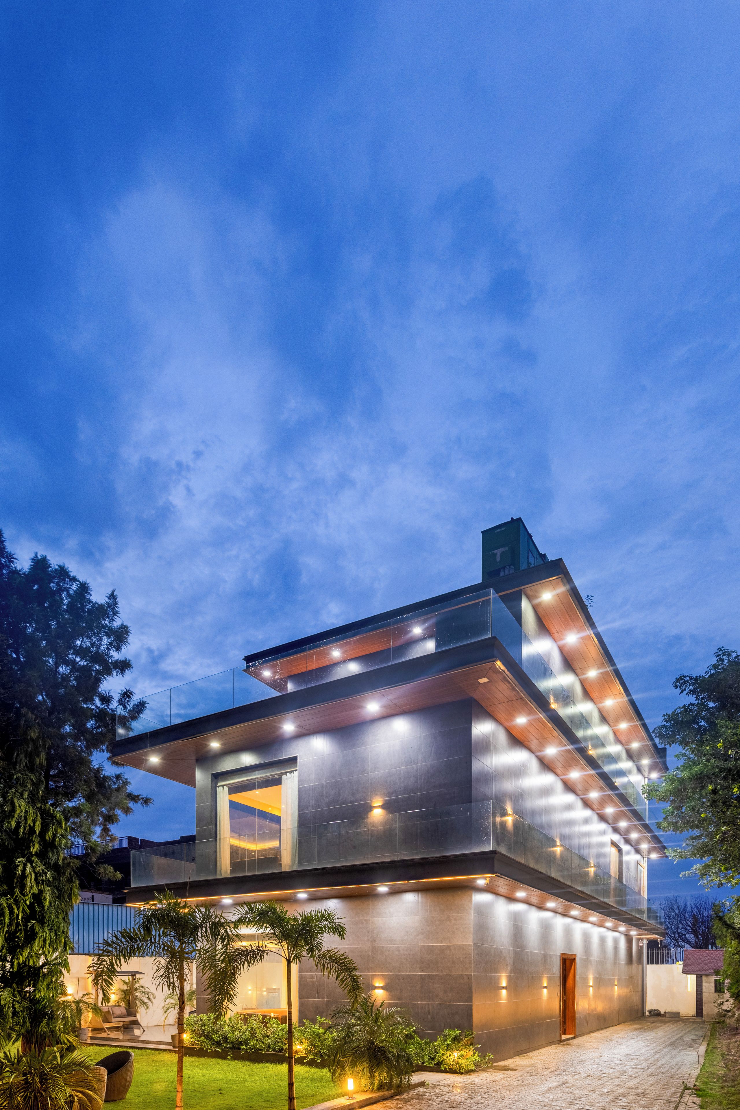 A modern multi-story building with a flat roof, large windows, and a well-lit exterior.