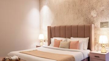 A modern bedroom with a large bed, bedside tables, a ceiling fan, and a decorative rug.
