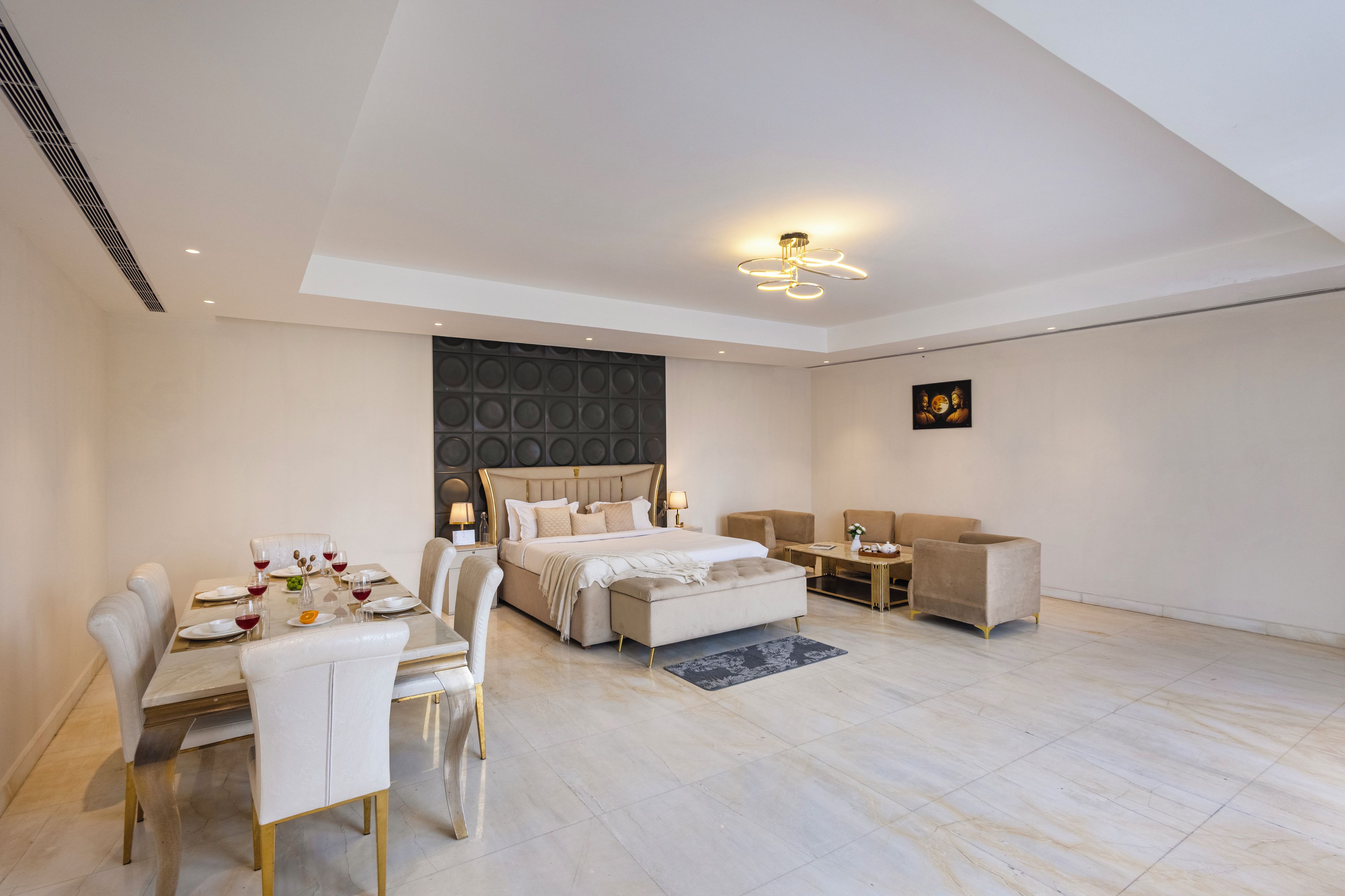 Ein modernes Schlafzimmer mit einem großen Bett, einem Esstisch und einer Sitzecke.