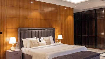 Un dormitorio moderno con una cama grande, dos lámparas de noche, una mesita de noche y un cabecero de madera.