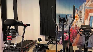 A gym with treadmills, a stationary bike, and a rowing machine.