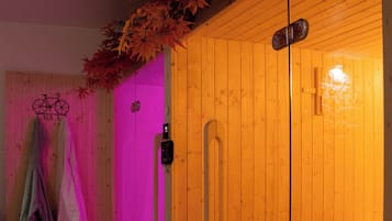 Un cuarto de sauna con paredes y bancos de madera, una puerta de cristal y un soporte para bicicletas.