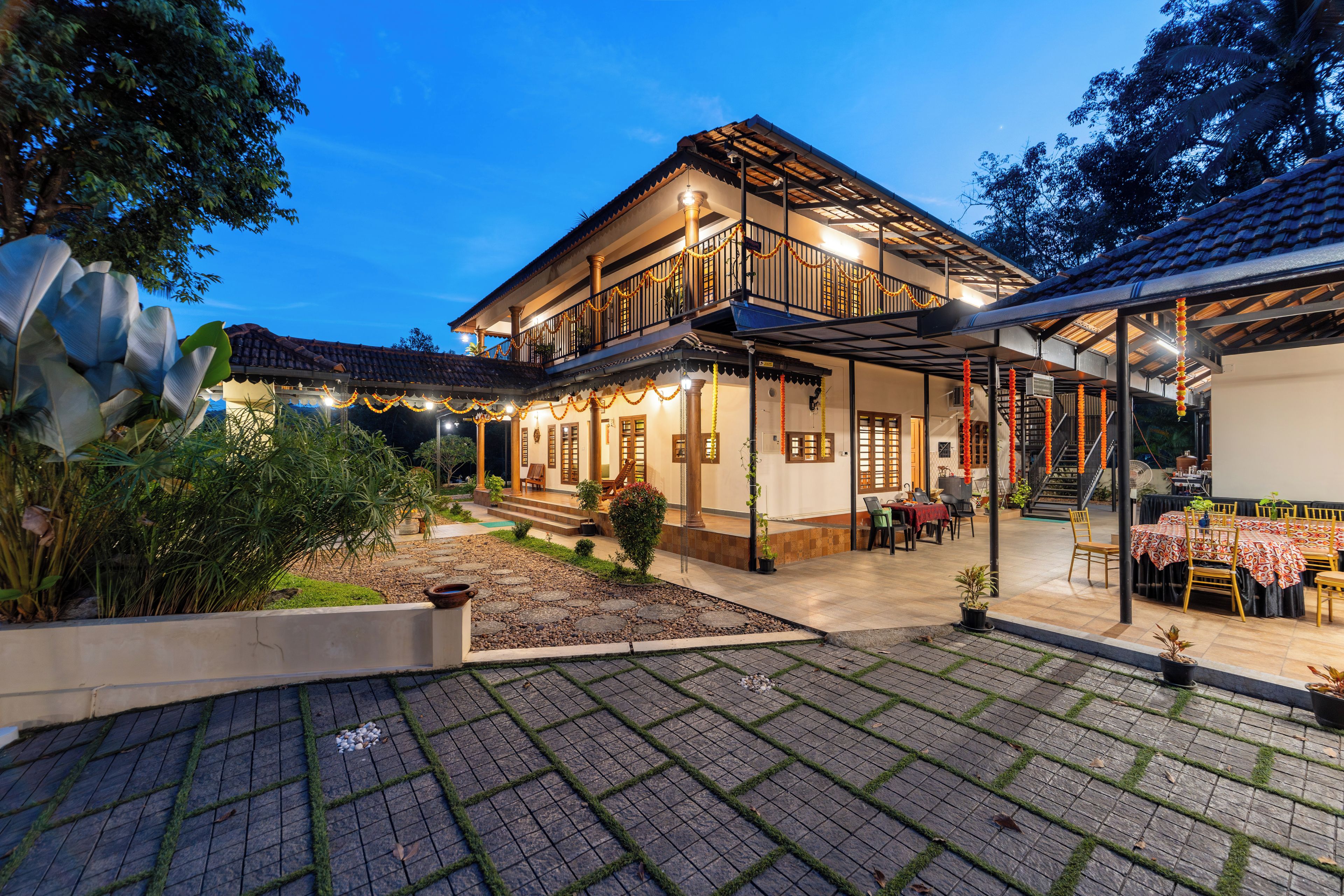 A two-story building with a covered patio area, outdoor seating, and a well-maintained garden.