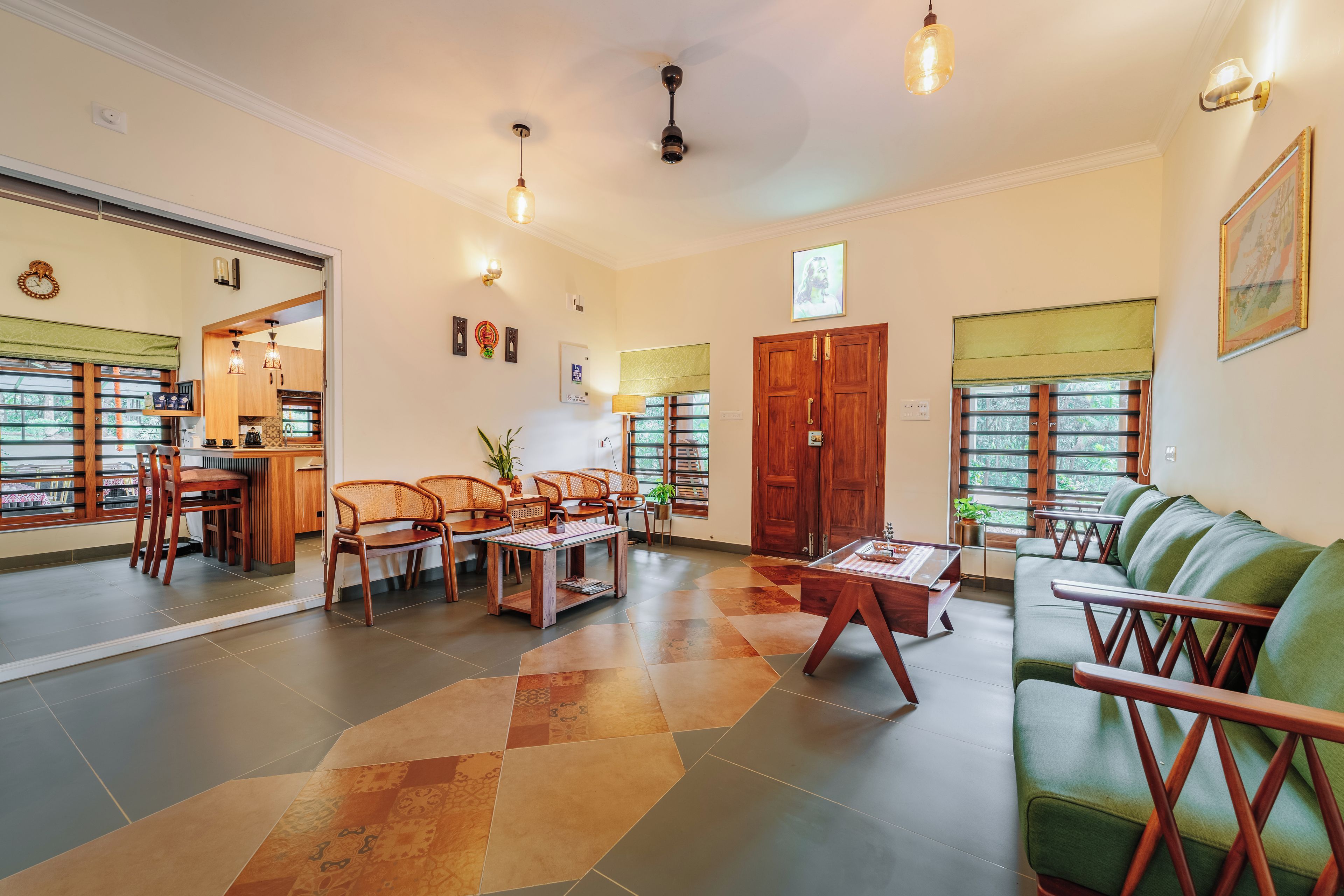 A spacious living area with a green sofa, wooden coffee table, and a dining area with wooden chairs and a table.