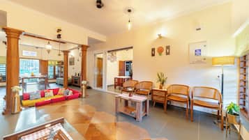A spacious living area with a sofa, chairs, a coffee table, and a dining table.