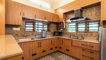 A modern kitchen with wooden cabinets, a stainless steel range, and a microwave.