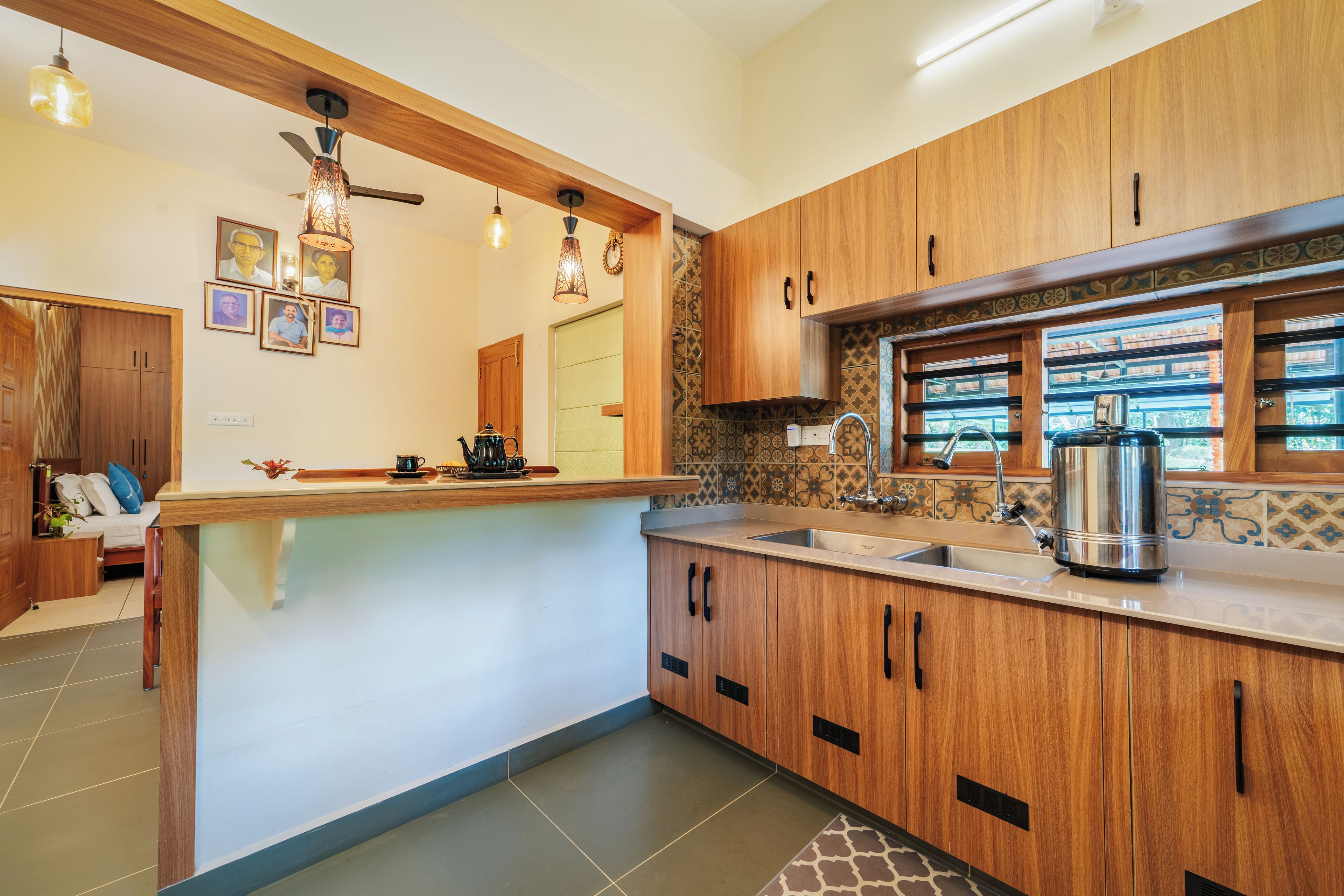Una cocina moderna con armarios de madera, un lavamanos integrado y una cafetera.
