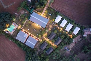 An aerial view of a residential area with multiple houses, a swimming pool, and a well-lit pathway. - Jungle Book Ranthambore (Sawai Madhopur)