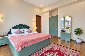 Un dormitorio moderno con cama, mesitas de noche, armario, espejo y planta en maceta.