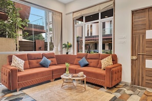 A modern living room with a sectional sofa, a coffee table, and a patterned rug.