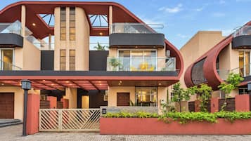 Ein modernes, mehrstöckiges Gebäude mit einem einzigartigen architektonischen Design, mit Balkonen und einem verschlossenen Eingang.