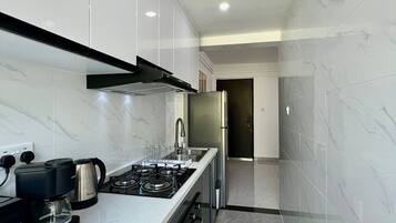 A modern kitchen with a gas stove, coffee maker, and stainless steel appliances.