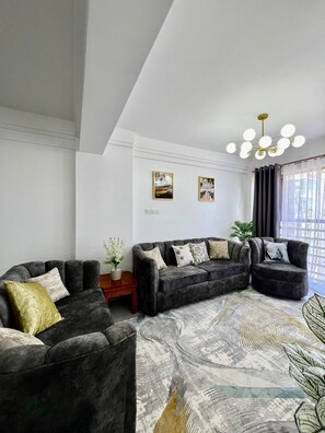 A modern living room with a sectional sofa, a small wooden side table, and a decorative plant.