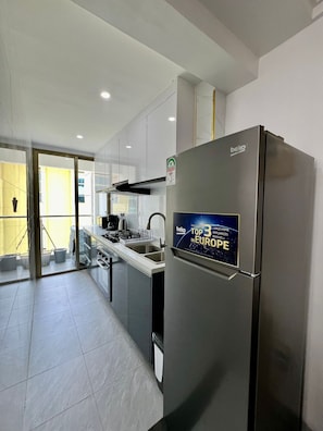 Eine moderne Küche mit einem Edelstahlkühlschrank, einem Backofen und einem Spülbecken.