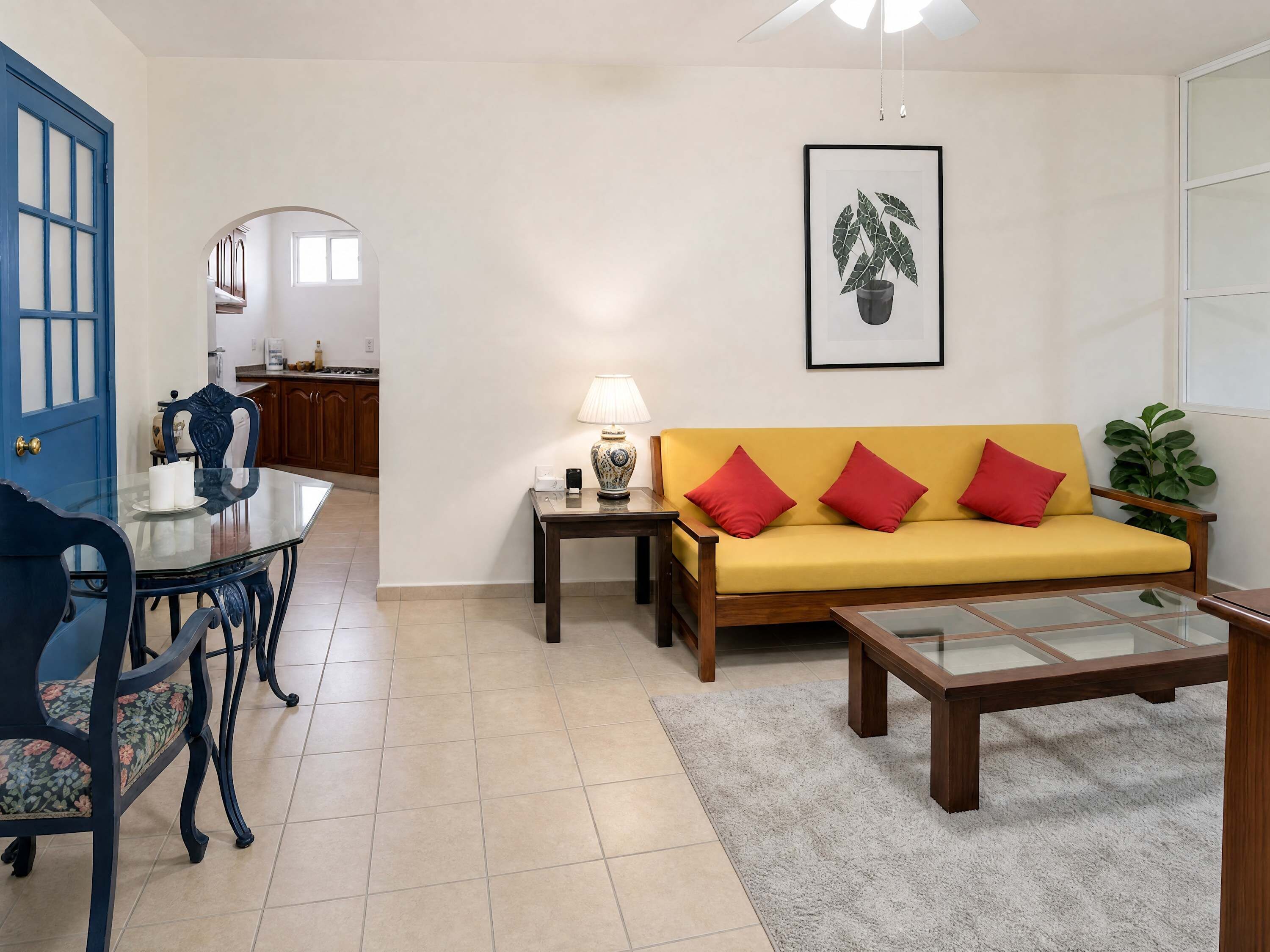A living room with a sofa, a coffee table, and a dining area with chairs and a table.