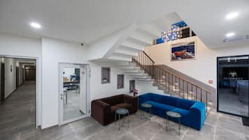 Un interior moderno con una escalera, un sofá azul y un sofá marrón.