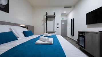 Een hotelkamer met twee bedden, een televisie en een bureau.