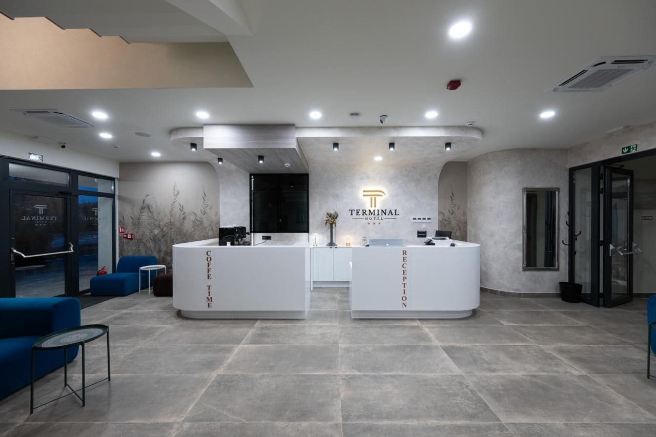 A reception area with two white reception desks labeled 'Terminal Coffee Time' and 'Reception.'