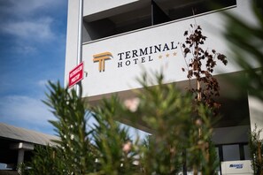 Un edificio con un letrero que dice 'Terminal Hotel' y un letrero rojo que indica 'registro de IVA'.